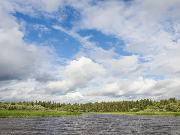 Değiştirilebilir bulutlu parlak güneşli rüzgarlı Ağustos gününde Vozhe Gölü manzarası