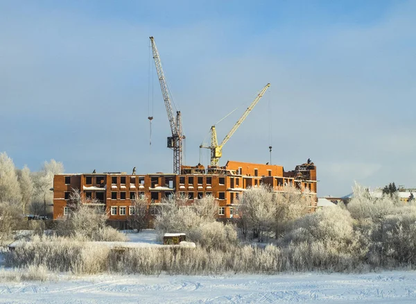 Nehir kıyısında kışın inşaat, düşük katlı tuğla bina