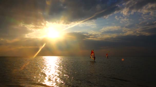 夕日の波動にウィンド サーフィンの練習スローモーションの若い男 — ストック動画
