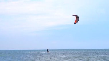 Genç adam Kitesurfing dalgalar üzerinde pratik
