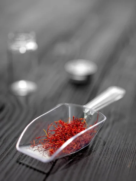 Dried saffron in  spoon on black background — Stock Photo, Image