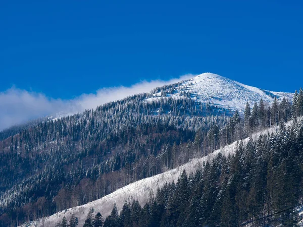 雪崩を吹き飛ばす山の頂上に巨大な風の突風 — ストック写真