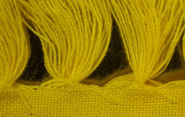 İplik püsküllü sarı bir Amerikan Servisi kenarı boyunca genel gider closeup görünümü. Püsküllü yinelenen bir düzen.