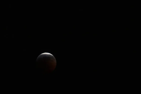 Earth's moon is near total eclipse by the earth during a total eclipse in January 2019. A reddish cast is visible on the moon, hence the term 'blood moon'. It is also near its closest approach to the earth, hence 'super'.