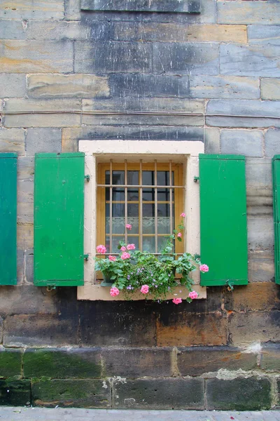 Janela com flores em uma casa velha . — Fotografia de Stock