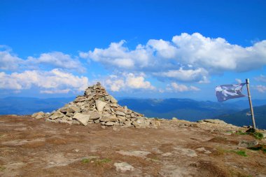 Fotoğraf Karpat Dağlarında çekildi. Hoverla adı verilen dağın zirvesine giden yolda ev yapımı bir anıt resmi gösterir.