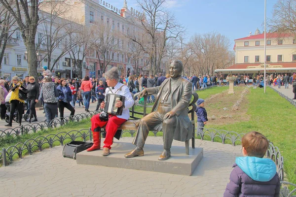 Musicien de rue jouant près de la sculpture de Leonid Utesov . — Photo