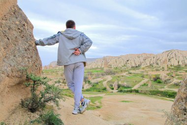 Genç adam kapadokya dağlarının güzel manzarasının tadını çıkarıyor.