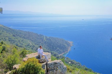 Genç bir adam bir şey hayal, yüksek ten denize bakarak 
