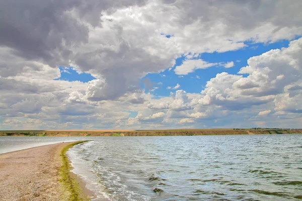 Bulutlu bir gökyüzünün altında haliçte bırakarak kum tükürmek.