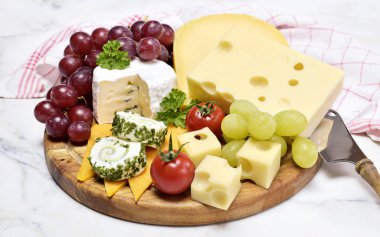 Lezzetli peynir tabağı ile çeşitli tür-in beğenmek Emmentaler, gouda ve brie peyniri. Gurme peynir beyaz beton arka plan ve Mutfak havlu ile ahşap kesme tahtası.