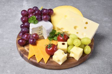 Lezzetli peynir tabağı ile çeşitli tür-in beğenmek Emmentaler, gouda ve brie peyniri. Gurme peynir beyaz beton arka plan ve Mutfak havlu ile ahşap kesme tahtası.