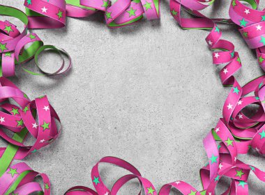 Doğum günü veya tatil arka plan beton zemin üzerine çok renkli kurdele ile. Kıvırcık şerit ve kopya alanı ile kutlama arka plan.