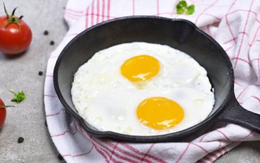 Lezzetli kızarmış yumurta dökme demir tavada. Yumurta ve ekmek, kahvaltı sahne üstten görünüm.