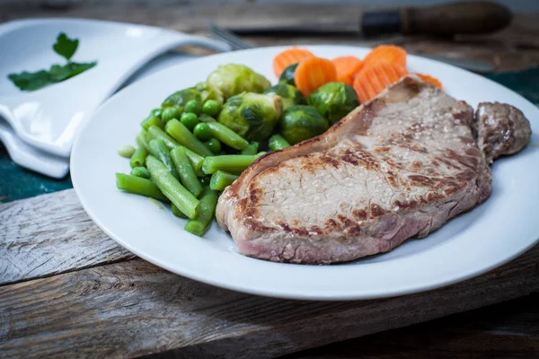 angus beef steak with vegetables served on dish