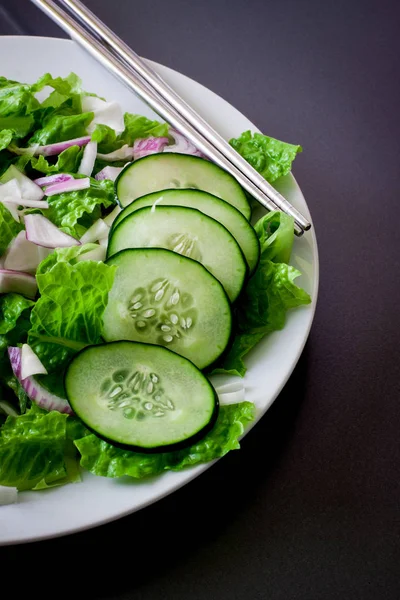 白色菜配筷子上的绿色沙拉 — 图库照片