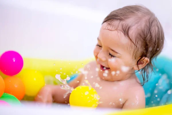 兴奋的男孩在浴缸里 可爱开朗的宝宝在孩子的浴缸里玩着五颜六色的球 带着快乐溅水 快乐健康的童年 — 图库照片