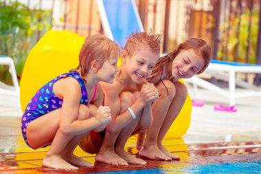 Eğleniyor aqua park, yaz kampı togethe içinde vakit zevk ile yakın arkadaşlarım havuzun oturan üç mutlu çocuk