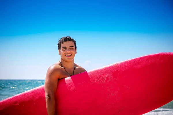 一个快乐的微笑的少年男孩与红色冲浪板站在海滩上 期待良好的海浪 愉快的活跃暑假 — 图库照片