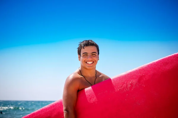 快乐的男孩享受冲浪 欢快的青少年与红色冲浪板在海边 运动身体 年轻人做水上运动在暑假 — 图库照片