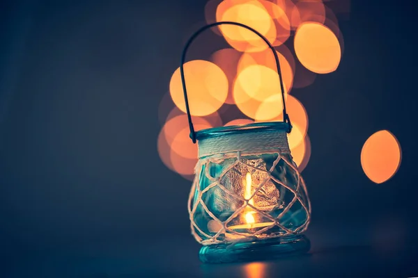 Romantic candlelight atmosphere, beautiful vintage candle lantern burning on mild blurry lights background, beauty and romance concep