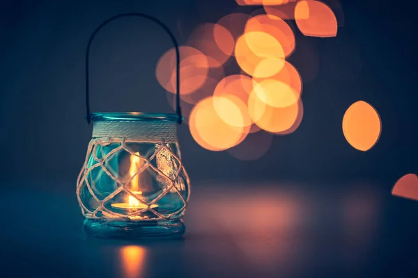 Romantic candlelight atmosphere, beautiful vintage candle lantern burning on mild blurry lights background, beauty and romance concep