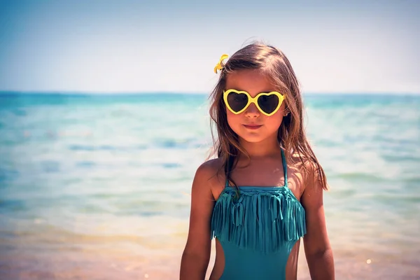 一个可爱的小女孩在海滩上的肖像 迷人的孩子穿着时髦的泳装和心形太阳镜 婴儿时尚 快乐的暑假 — 图库照片