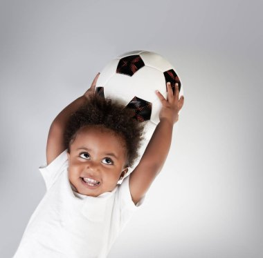 Topu ile şirin küçük bir çocuk portresi, futbol topu ile sevimli küçük kaleci açık arka plan üzerinde mutlu active childhoo eller.