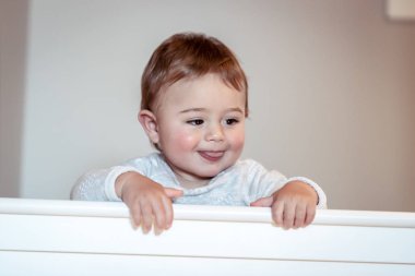 Tatlı bebek çocuk ayakta onun güzel beyaz karyolası, biraz kestirmek hazırlanıyor çocuk kidsroom evde Pijama içinde mutlu çocukluk içinde
