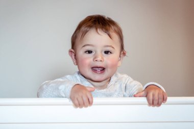 Çocuk odası, çok güzel bebek giyen pijama, mutlu sağlıklı çocukluk beşiğinde ayakta küçük şirin bir çocuk portresi
