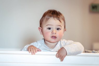 Çok güzel bebek pijama, mutlu sağlıklı childhoo giymiş çocuklar yatak, beşiğinde ayakta küçük şirin bir çocuk portresi