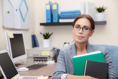 Ciddi iş kadını ofiste otururken elinde belgelerle portresi finans sektörünün, akıllı insanlar ve sert iş concep bir kariyer yapmak