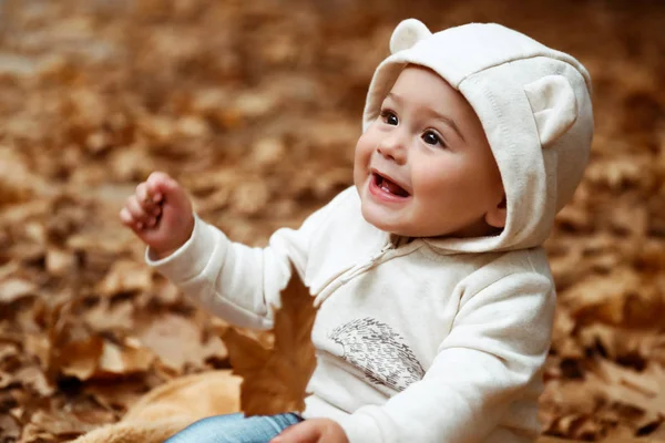 Ağaç Yaprağı Yere Oturmuş Elinde Bir Şirin Bebek Çocuk Portresi — Stok fotoğraf