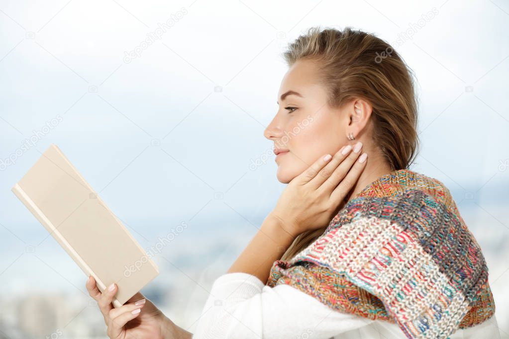 Profile view of a nice calm female reading book at home, authentic natural beauty of a young female enjoying good novel about lov