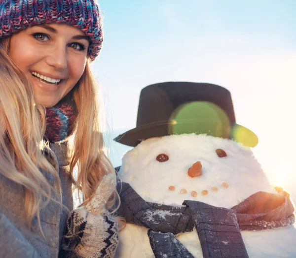 与雪人欢快笑容可亲的少女的肖像 传统的冬季游戏 年轻的成年女子尽情享受孩子们的冬季欢乐 快乐的寒假 — 图库照片