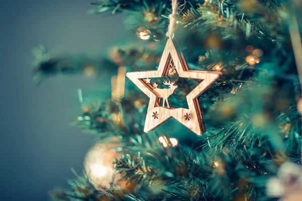 クリスマスツリーの装飾 モミの木にぶら下がっているトナカイと木製の星 美しいお祝いの背景 冬の休日の装飾 — ストック写真