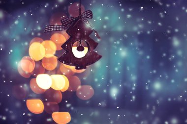 Güzel Noel dekoru, küçük ahşap süslemeli Noel ağacı mavi parlayan ve kar yağan arka plan, Mutlu Noeller tebrik kartı 