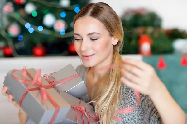 漂亮的女人享受着圣诞礼物 等待着所有礼品盒的打开 在家里度过寒假 还装饰着美丽的圣诞树 — 图库照片