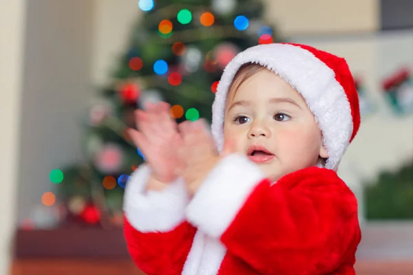 一个可爱的快乐的小男孩在圣诞节前夕在家里玩得开心的画像 一个穿着圣诞老人服装的可爱的孩子在圣诞树旁拍手叫好 — 图库照片