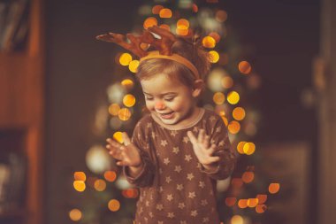Çocukların Noel partisinde bir bebek, Rudolph kostümlü şirin bir bebek matinenin tadını çıkarıyor ve Noel ağacının yanında tatiller geçiriyor. 