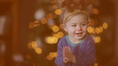 Şirin bebek çocuk Ren geyiği boynuzları giyiyor. Dolu Hd Video