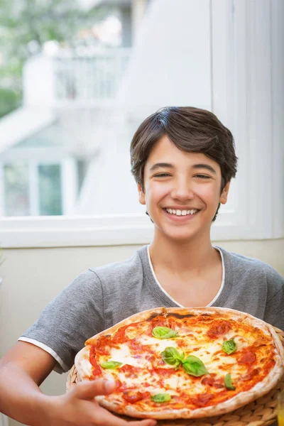 ハッピーティーンの男の子は 伝統的なおいしいイタリア料理を楽しんで 自家製のピザを保持明るい笑顔ティーンエイジャー ピザを調理 — ストック写真