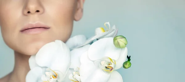 Portret Zbliżeniowy Kobiecej Twarzy Delikatnych Kwiatów Orchidei Białej Odizolowanych Szarym — Zdjęcie stockowe