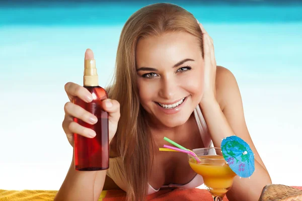 Gelukkige vrouw looien op het strand — Stockfoto