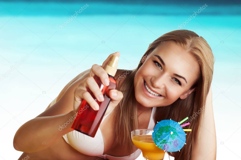 Woman on the beach using suncream