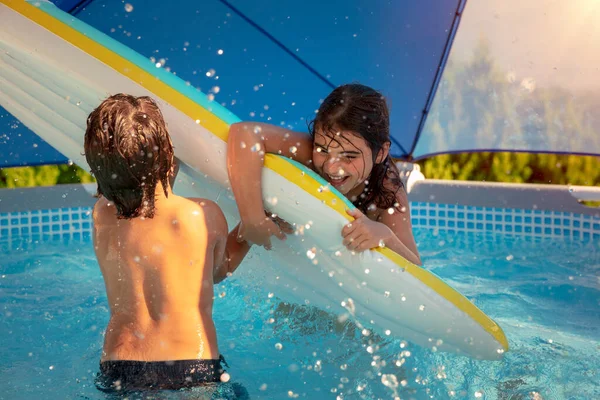 Двое Веселых Детей Играют Надувной Матрас Бассейне Разбрызгивая Воду Веселясь — стоковое фото