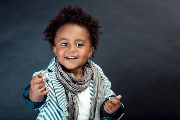 Studio Portrait of a Stylish Little African Boy with Curly Hair Isolated on Dark Background. Kids Fashion. Kids Clothes.