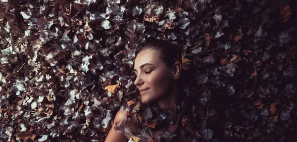 Kuru Ağaç Yaprakları Çiçekleri Yığınında Yatan Güzel Nazik Bir Kızın — Stok fotoğraf