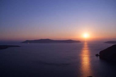 Santorini, Yunanistan - güneş, mavi gökyüzü, deniz ve kayalar görüntülemek