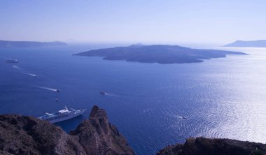 Santorini, Yunanistan - güneş, mavi gökyüzü, deniz ve kayalar görüntülemek